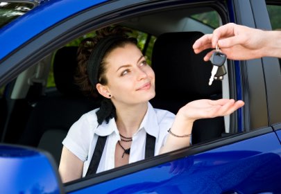 une femme reçoit les clés de sa voiture d'occasion